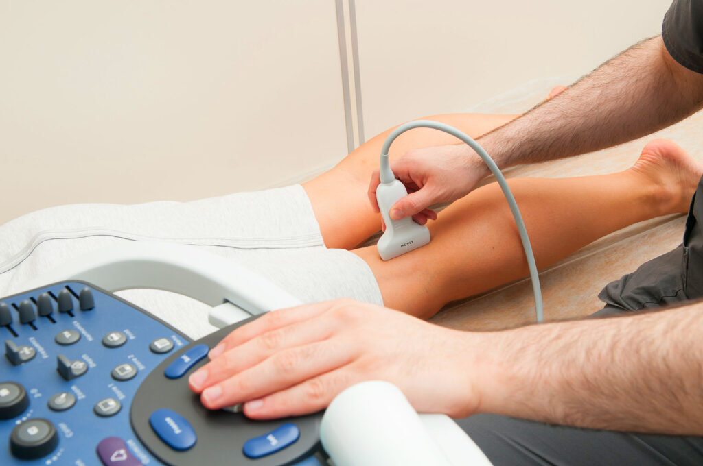 Doctor performing an ultrasound scan on a patient's leg