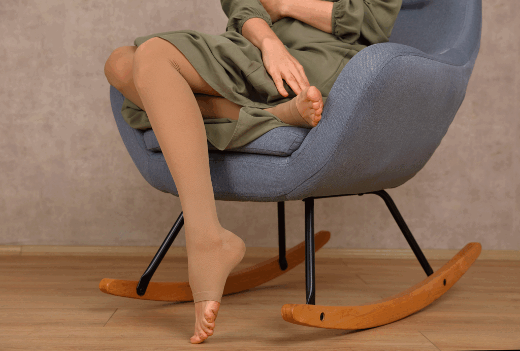 Woman sitting in a rocking chair wearing beige open-toe medical Compression Socks for leg support