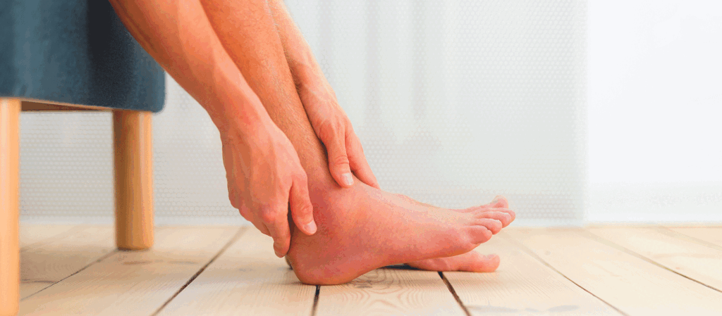 Person holding a painful and swollen ankle while learning about underlying conditions and asking can edema kill you.